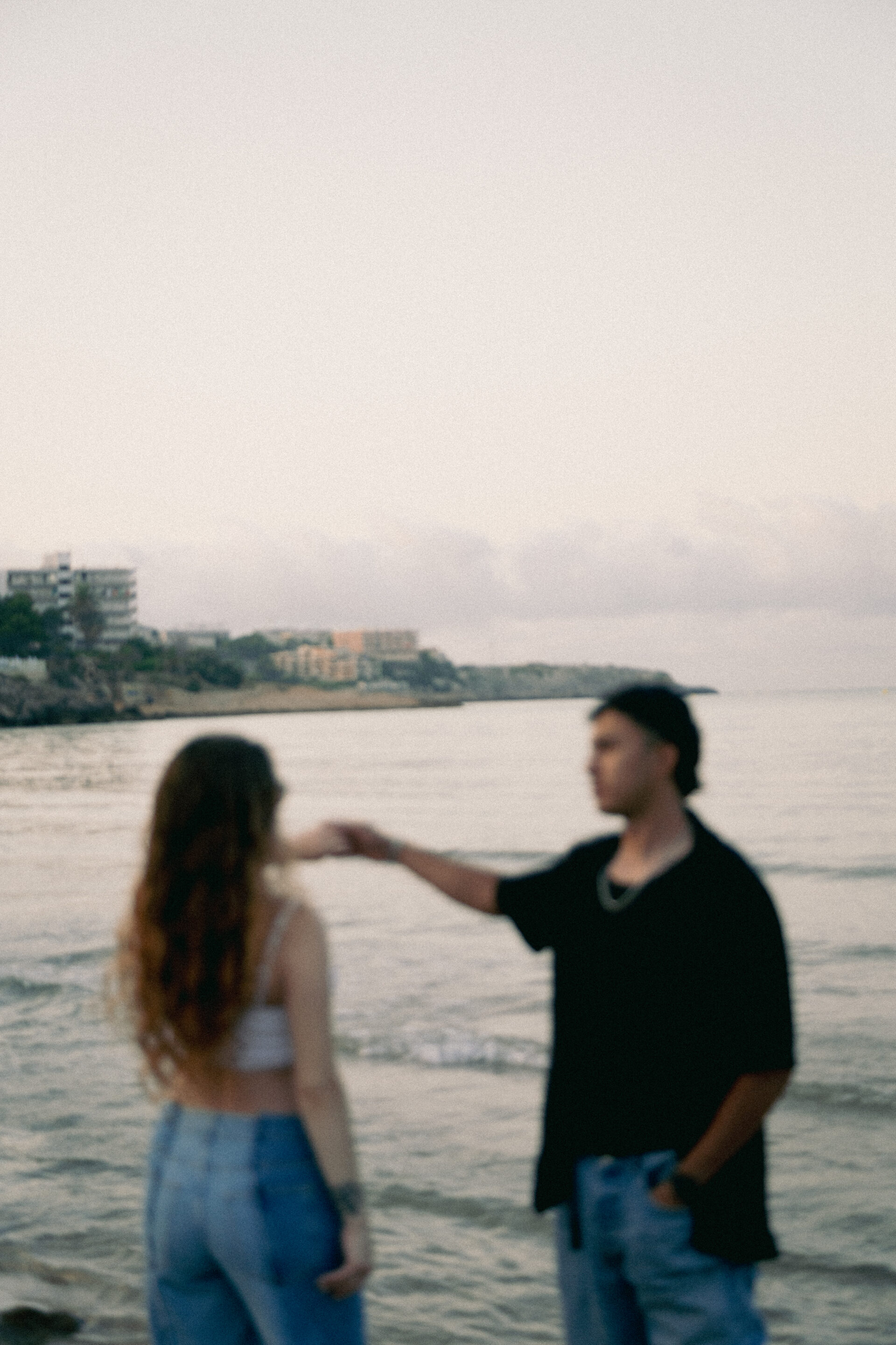 Fotografía profesional de pareja al atardecer en la playa de Tarragona, capturando momentos románticos con luz natural y edición meticulosa