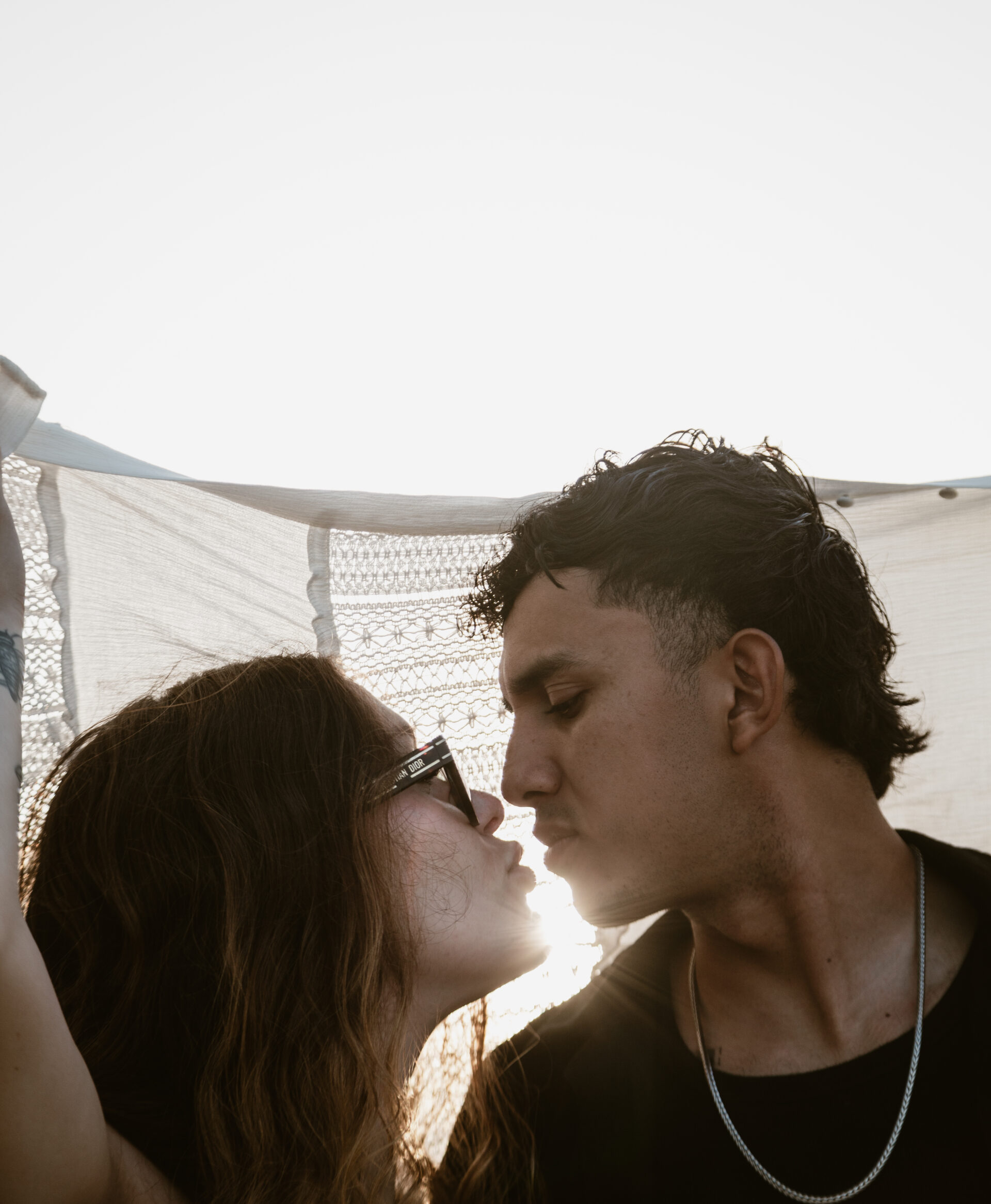 Fotografía profesional de pareja al atardecer en la playa de Tarragona, capturando momentos románticos con luz natural y edición meticulosa