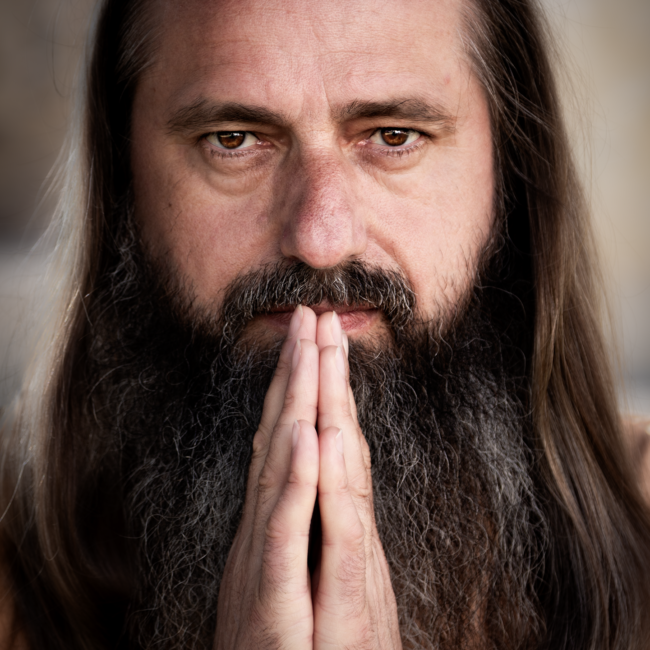 Retrato profesional de un hombre con expresión segura, iluminado con luz suave para resaltar detalles.