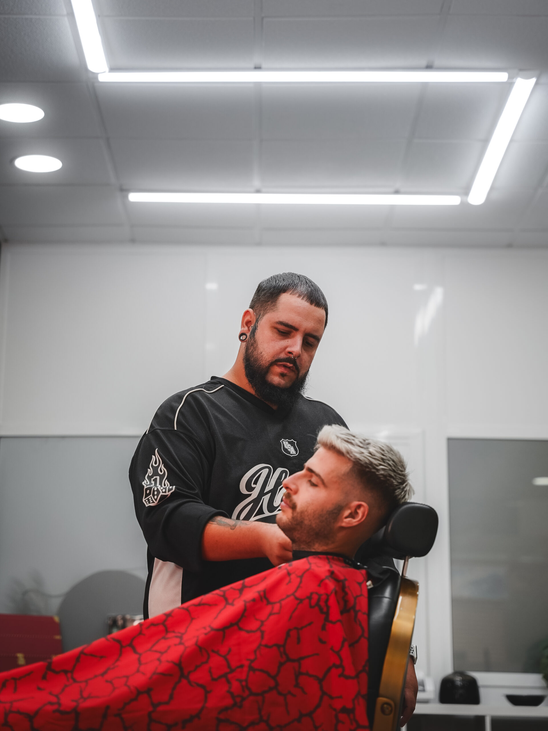 Barbero de LaFlame en acción perfilando la barba de un cliente con precisión.