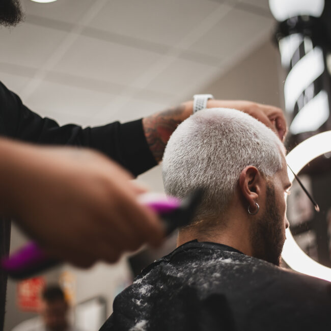 Barbero de LaFlame en acción perfilando la barba de un cliente con precisión.