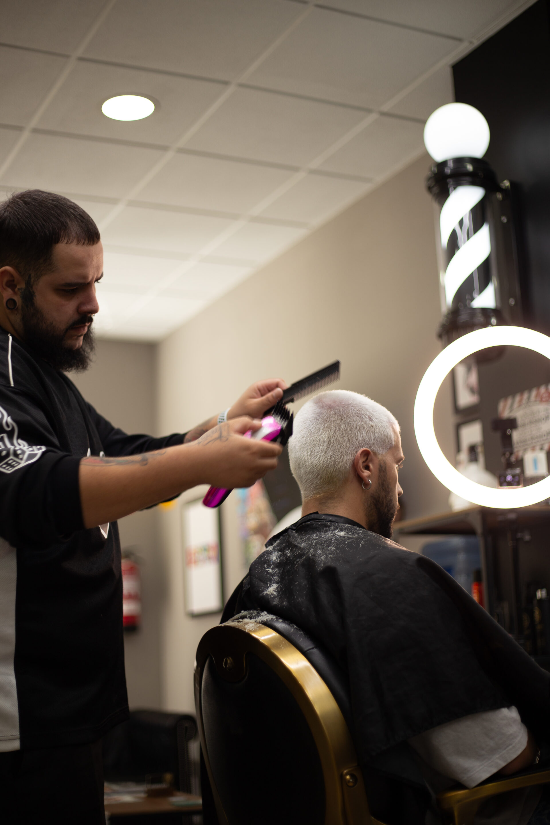 Barbero de LaFlame en acción perfilando la barba de un cliente con precisión.