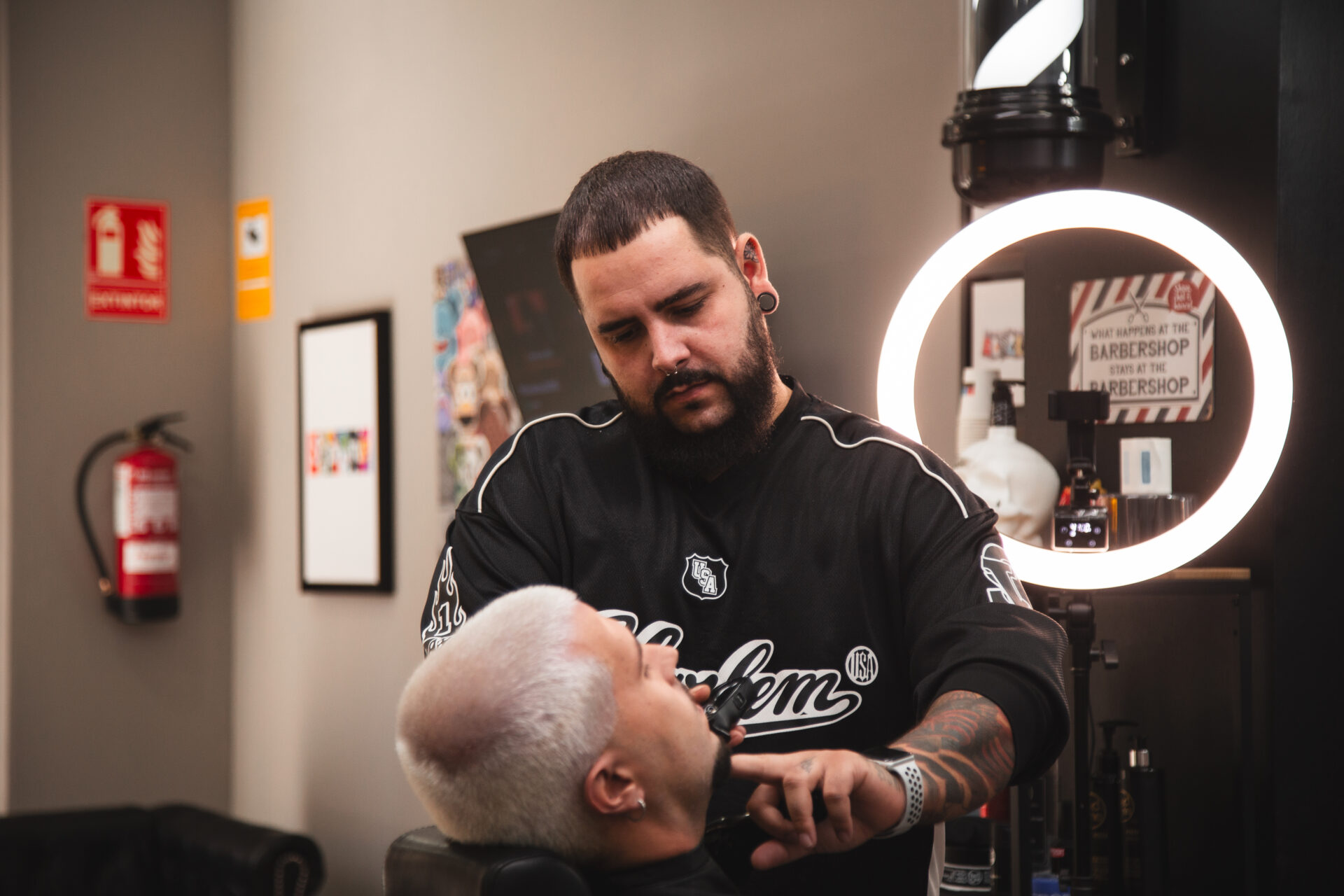 Barbero de LaFlame en acción perfilando la barba de un cliente con precisión.