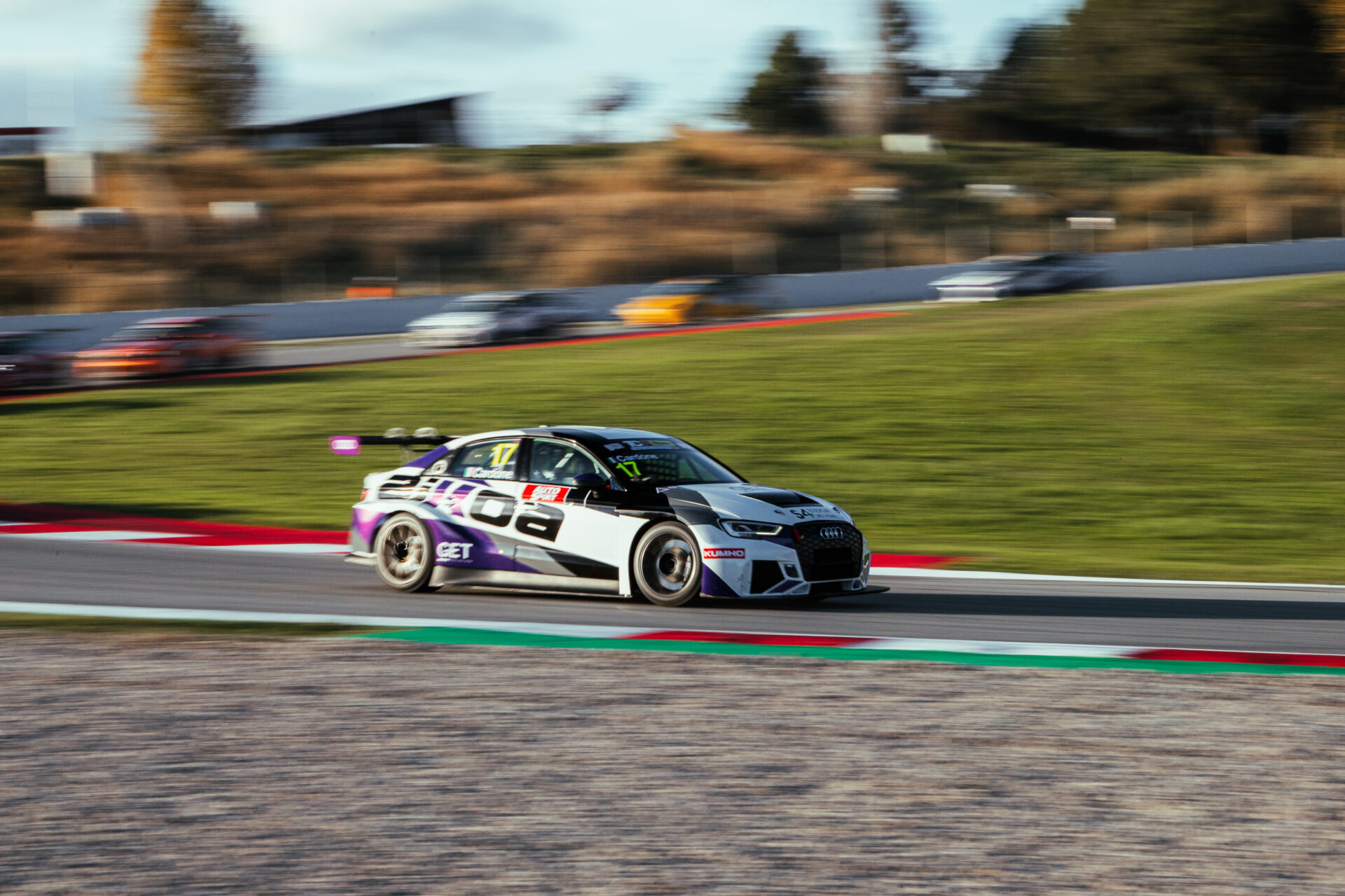 Vista lateral de un coche GT de alta gama alcanzando máxima velocidad en la recta del circuito GT-CET 2024.